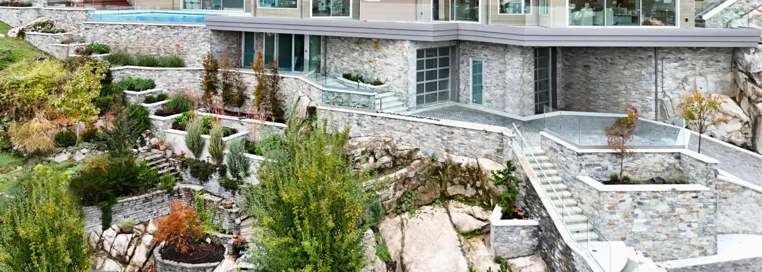 Hillside luxury residence in West Vancouver with tiered stone landscaping and modern heated driveway